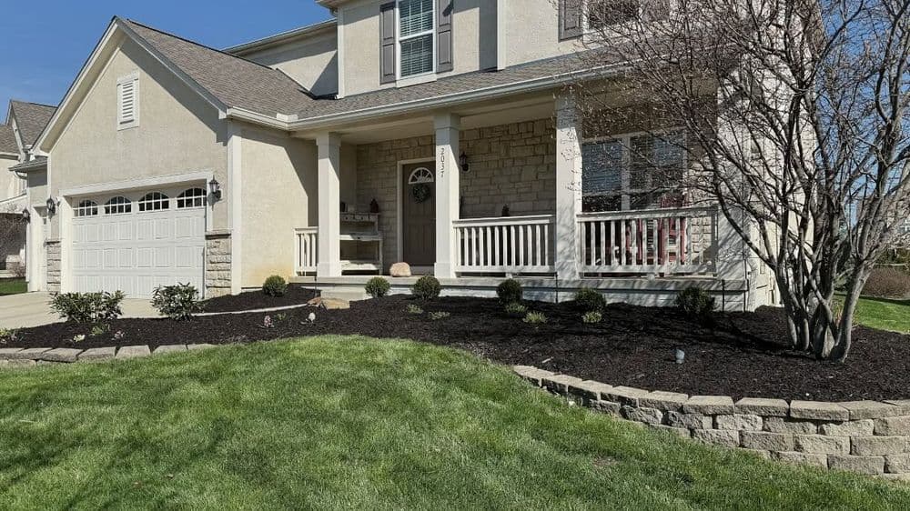 Exterior view of a charming house with a landscaped yard and porch on a sunny day.